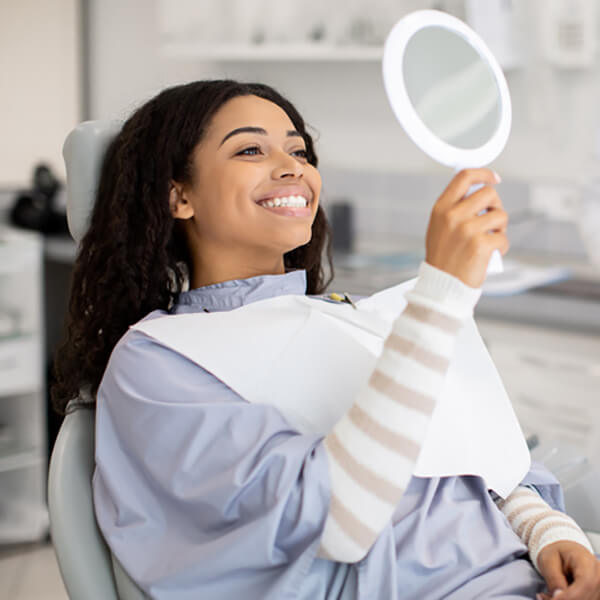 A woman checking her smile in the mirror